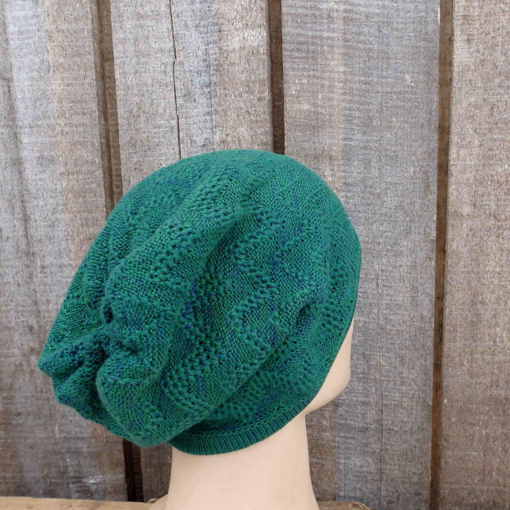 Green knitted hat on a mannequin head against a wooden background