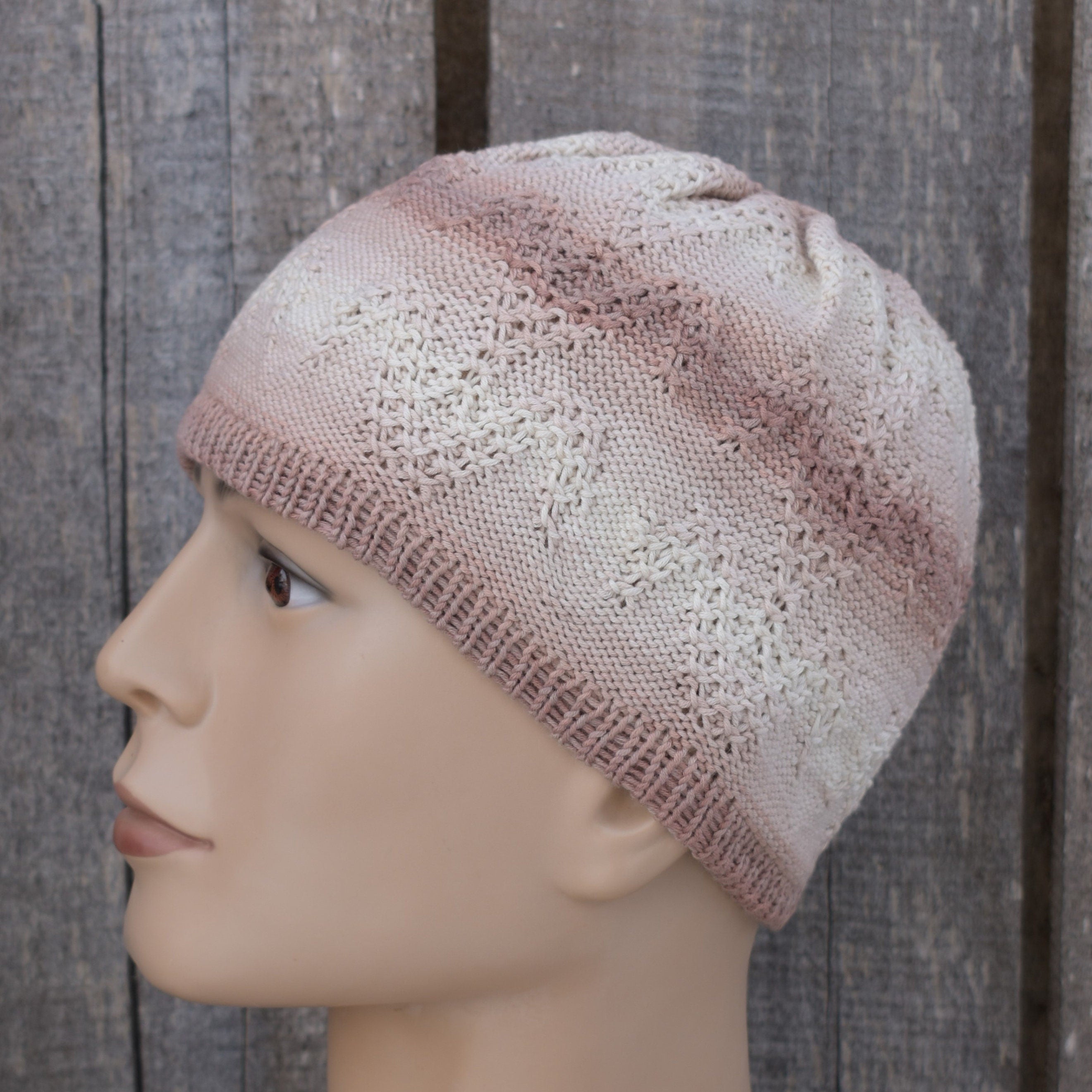 Knitted beanie on a mannequin head against a wooden background