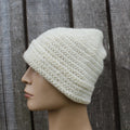 naalbinding beanie on a mannequin head against a wooden background