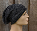 Black knit beanie on a mannequin head against a wooden background