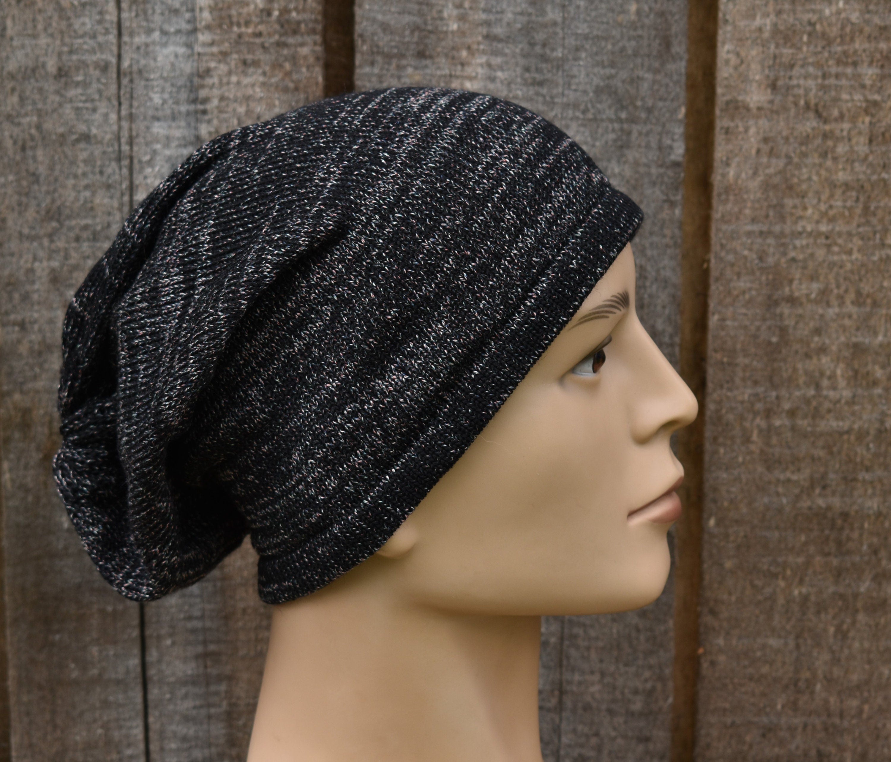 Black knit beanie on a mannequin head against a wooden background