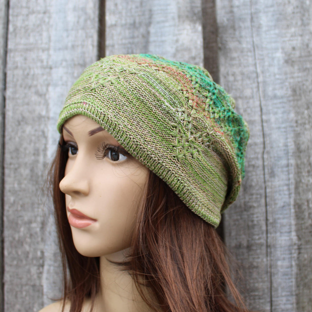 Green knitted hat on a mannequin head against a wooden background