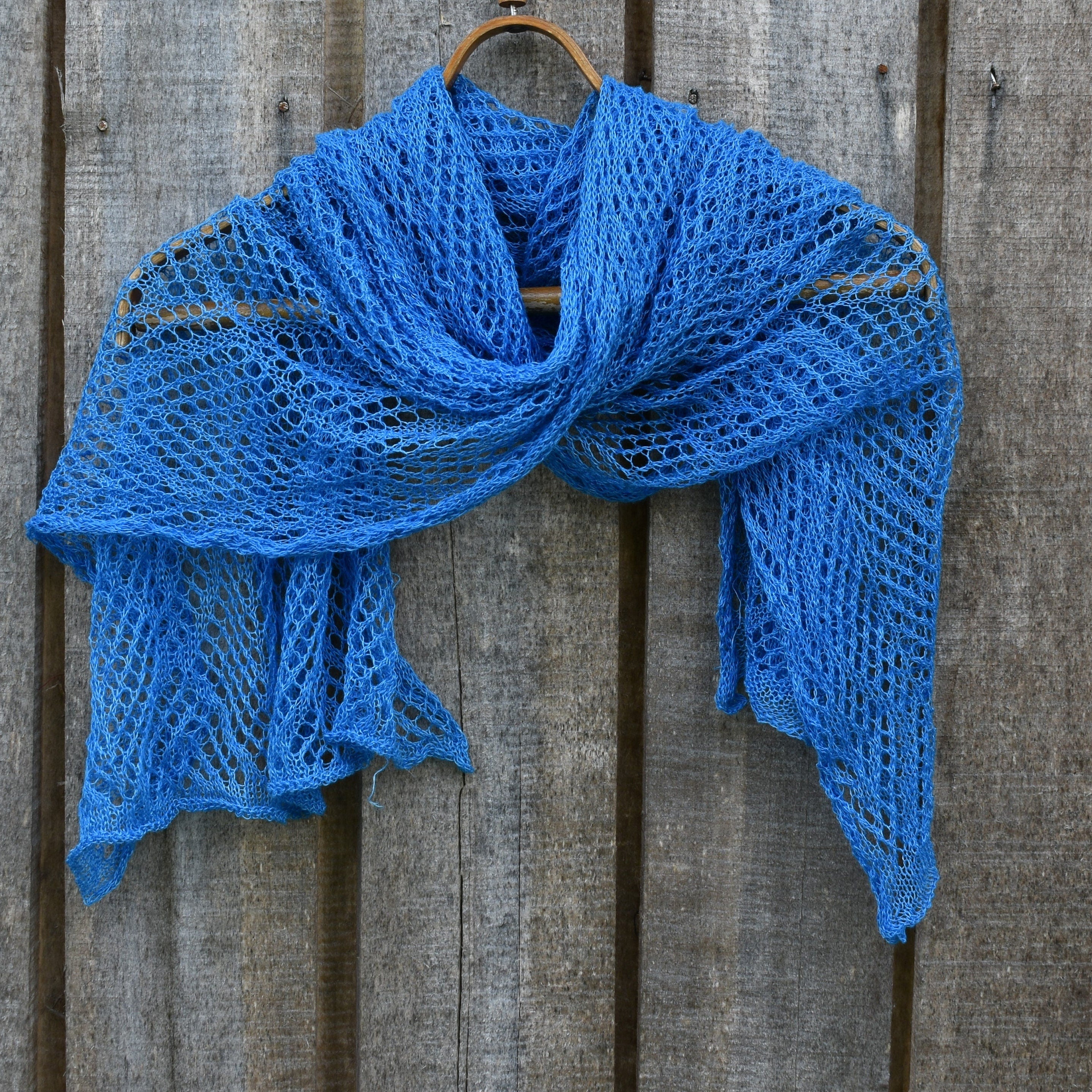 Blue knitted scarf on a wooden surface