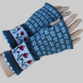 Pair of knitted fingerless gloves with floral pattern on a wooden surface