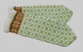 Pair of knitted mittens with a green and white pattern on a textured brown background