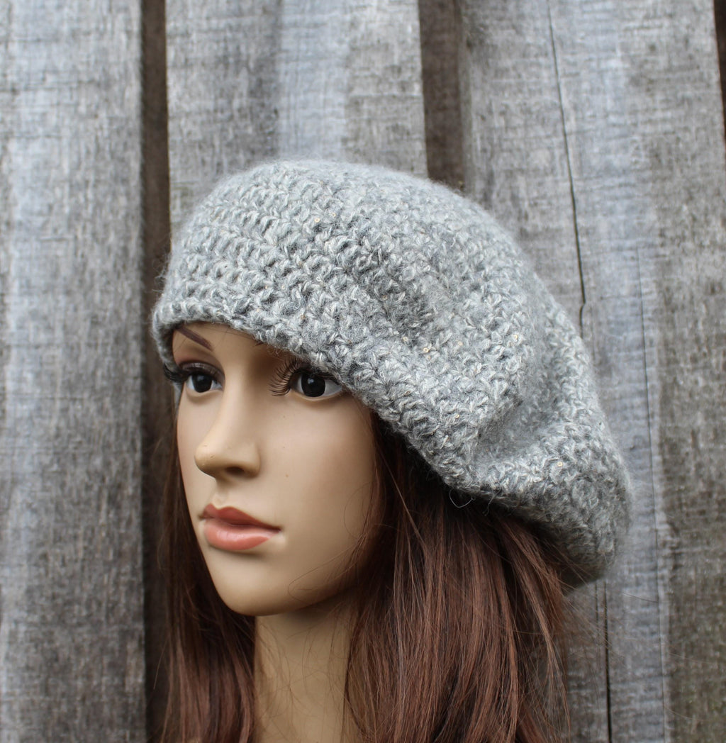 Mannequin head wearing a gray knit hat against a wooden panel background