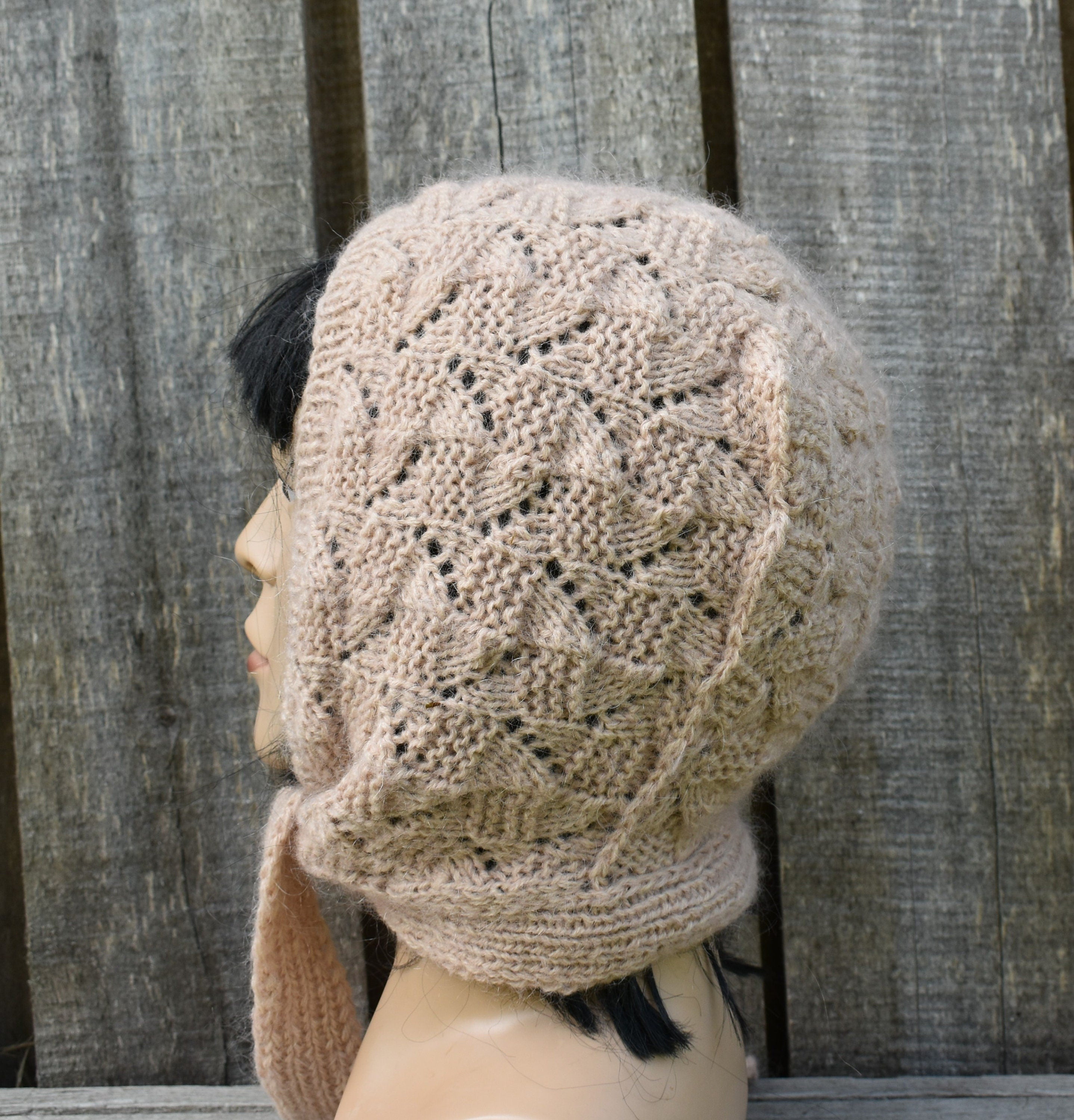 Knitted beige hat with a textured pattern on a wooden background