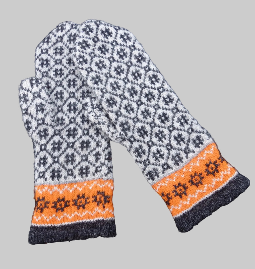 Pair of patterned mittens with orange and black design on a dark background