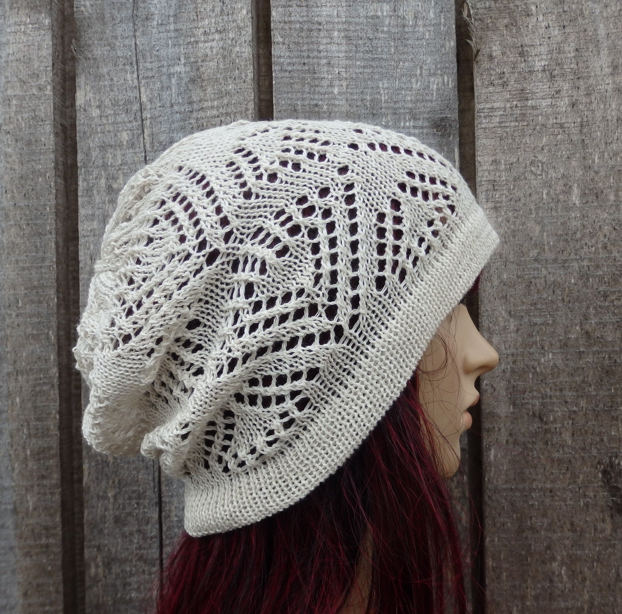 Knitted lace hat worn by a person against a wooden background