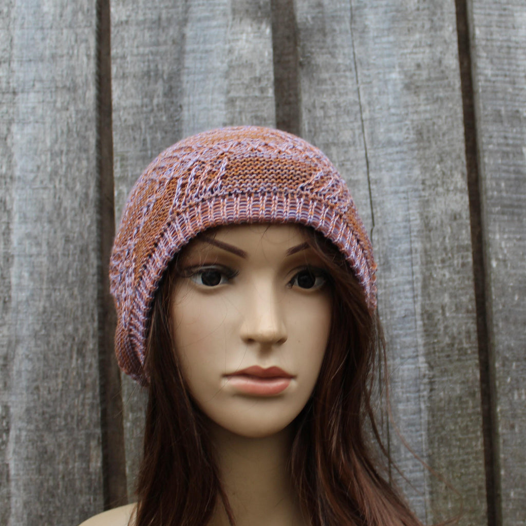 Mannequin head wearing a knitted hat against a wooden panel background
