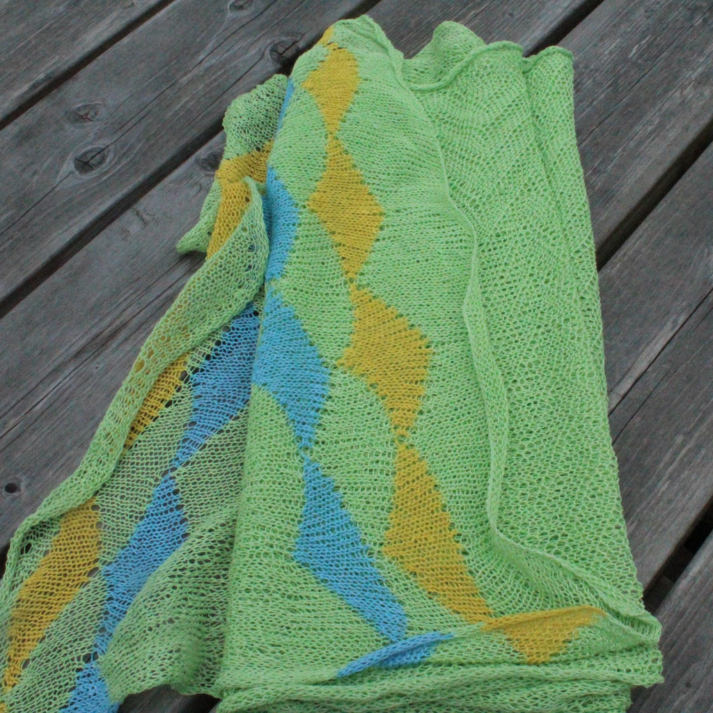 Green and yellow knitted fabric on a wooden surface