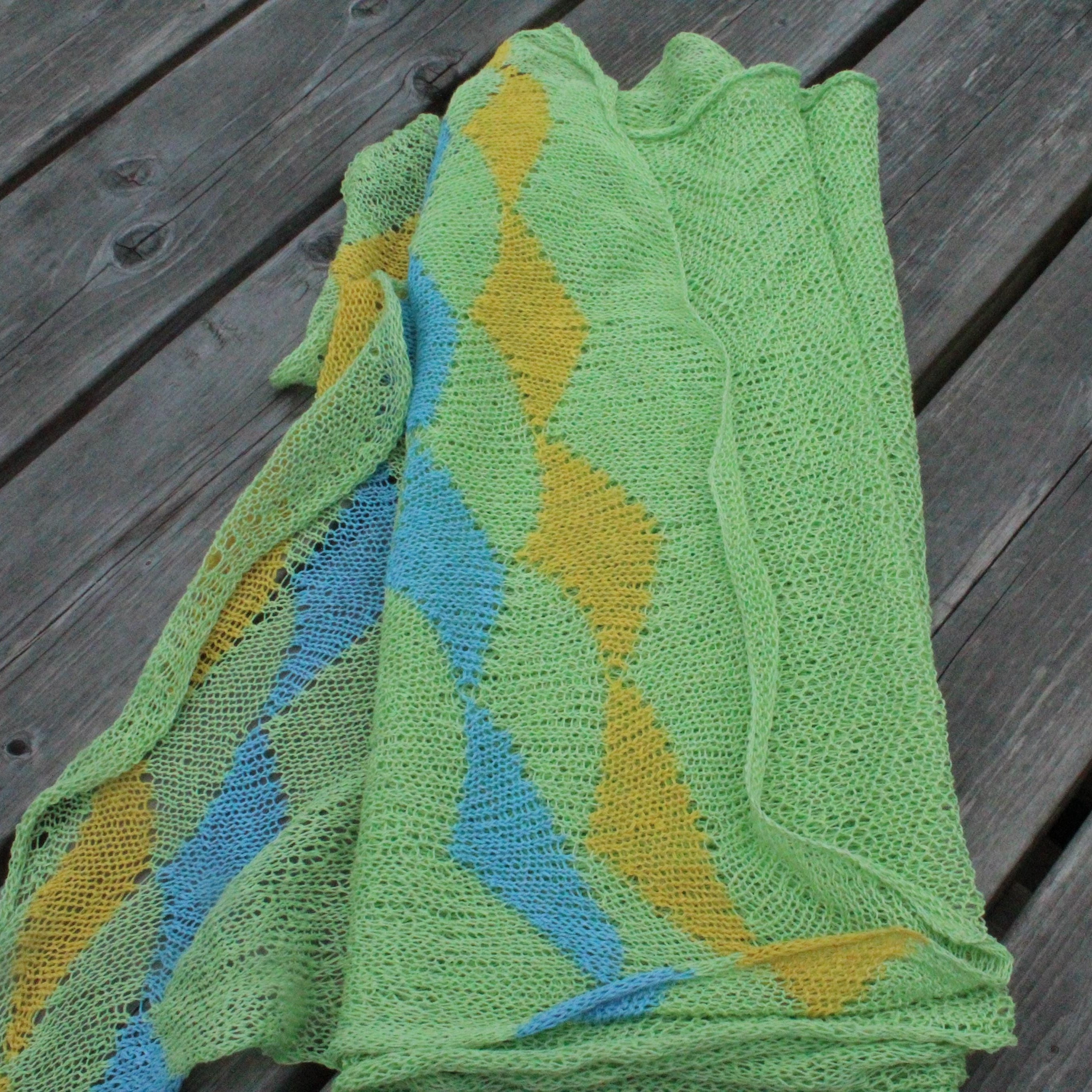 Green and yellow knitted fabric on a wooden surface