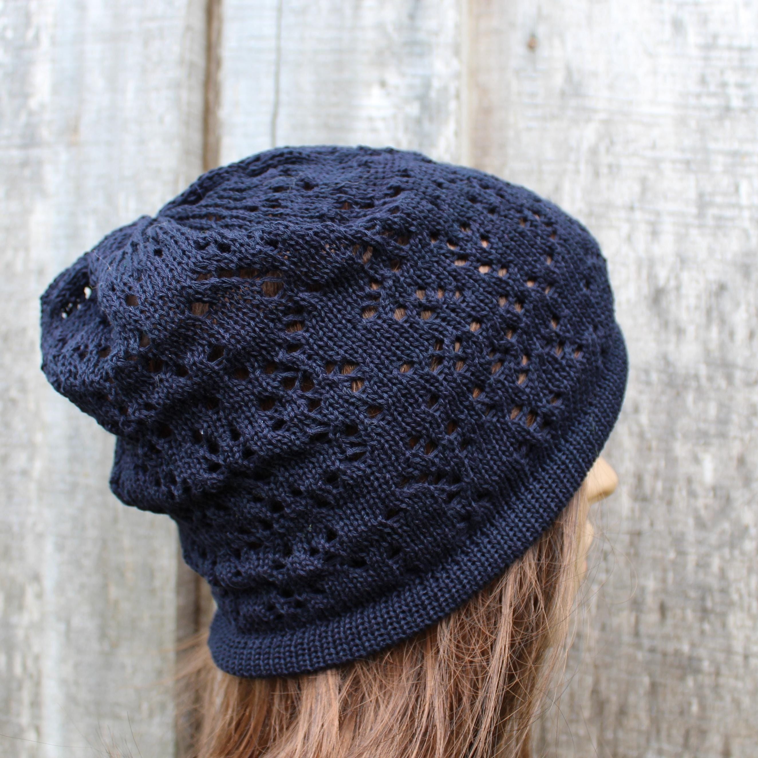 Navy blue knitted beanie on a mannequin head against a textured white background