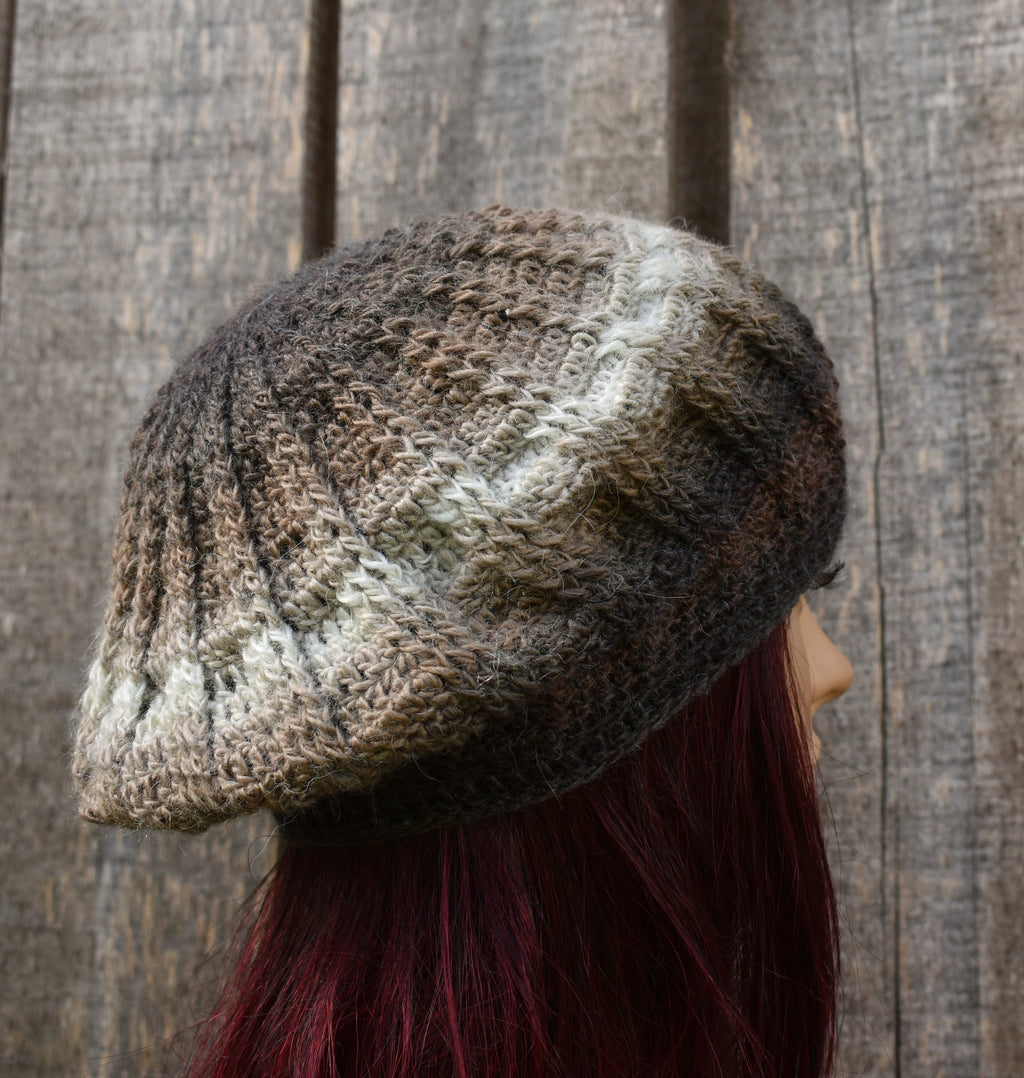 Person wearing a textured knit hat against a wooden background