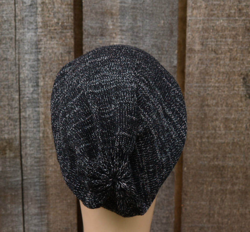 Dark gray knit beret on a mannequin head against a wooden background