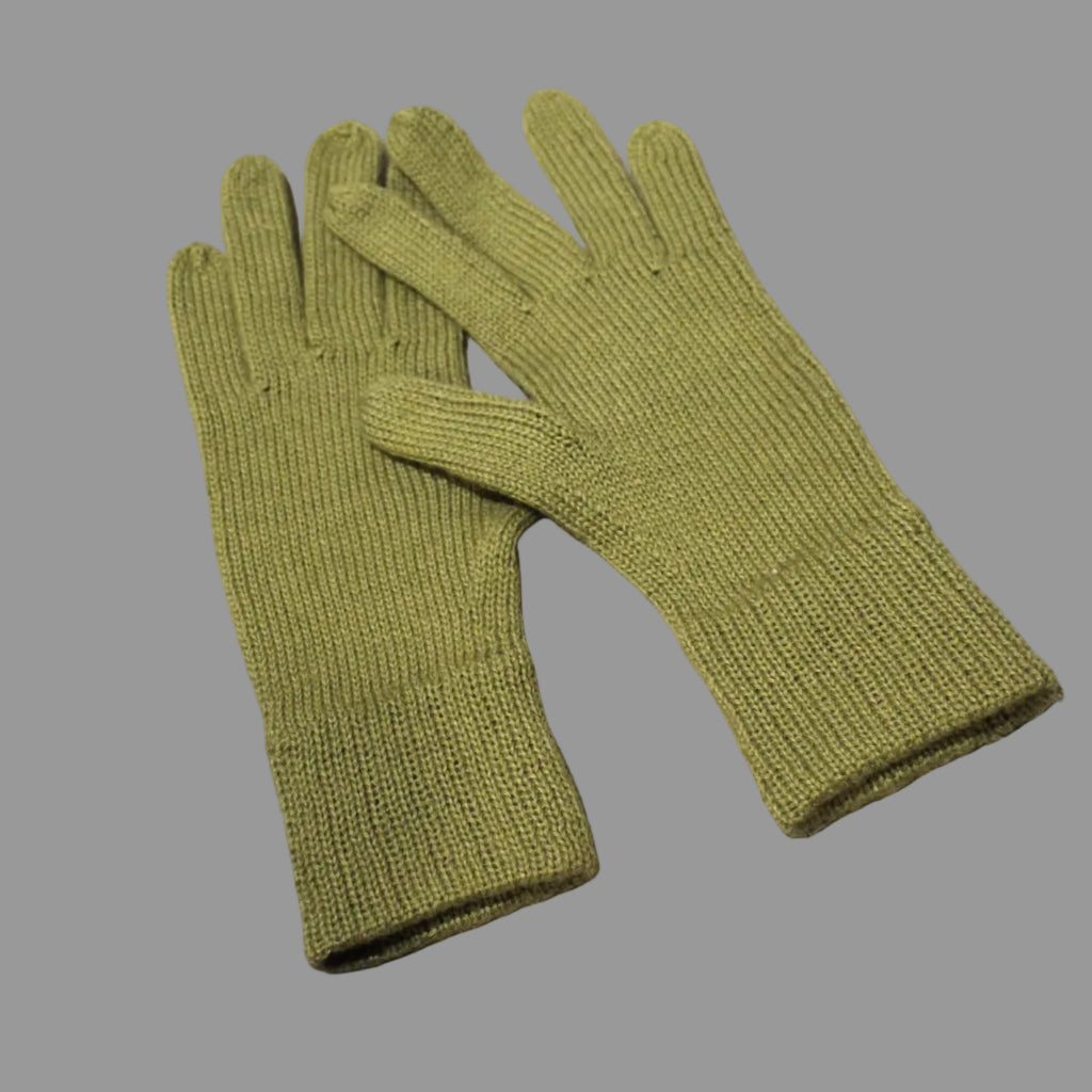 Pair of green gloves on a textured beige surface