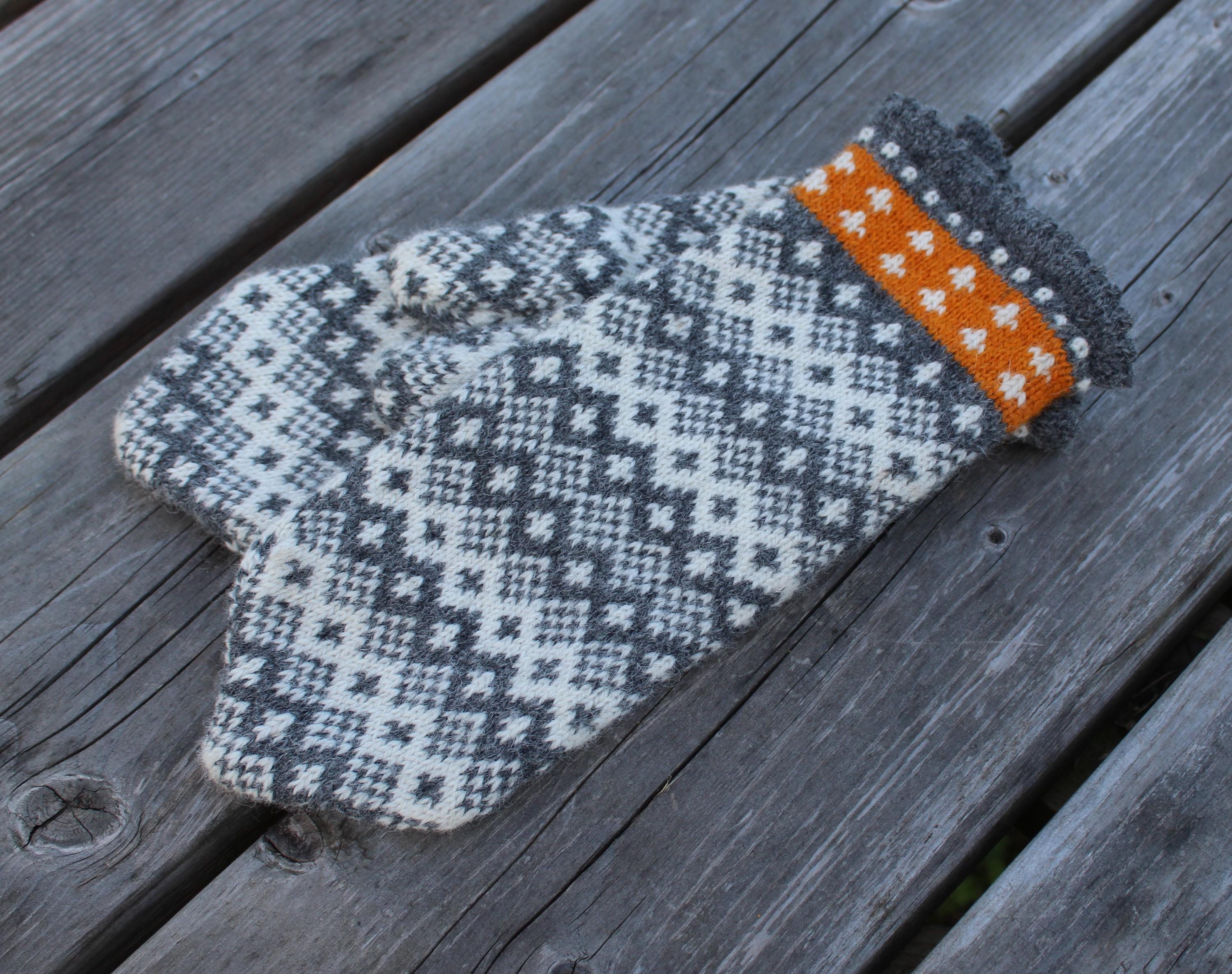 Knitted mitten with a pattern on a wooden surface