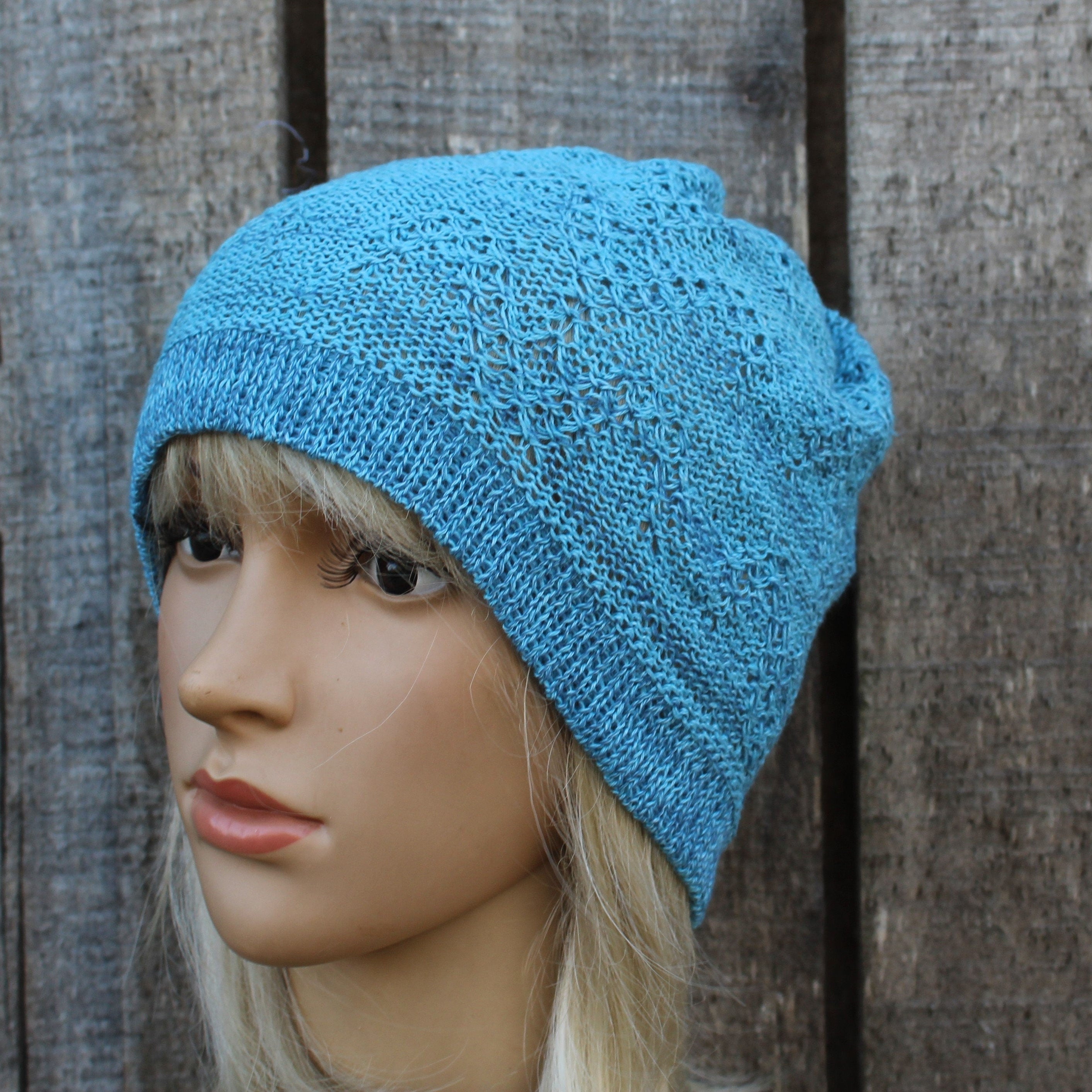 Blue knitted beanie on a mannequin head against a wooden background