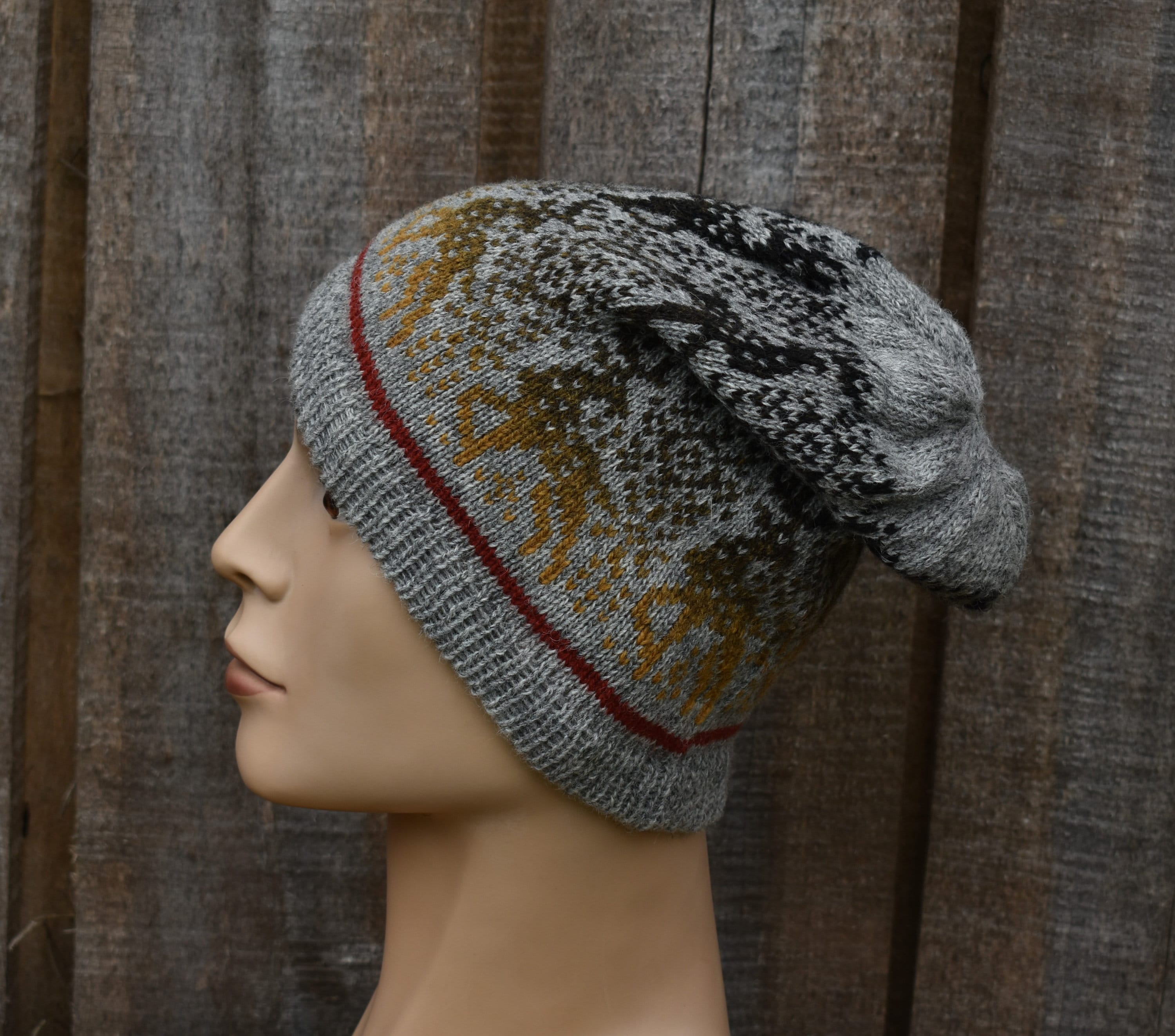 Knitted hat on a mannequin head against a wooden background