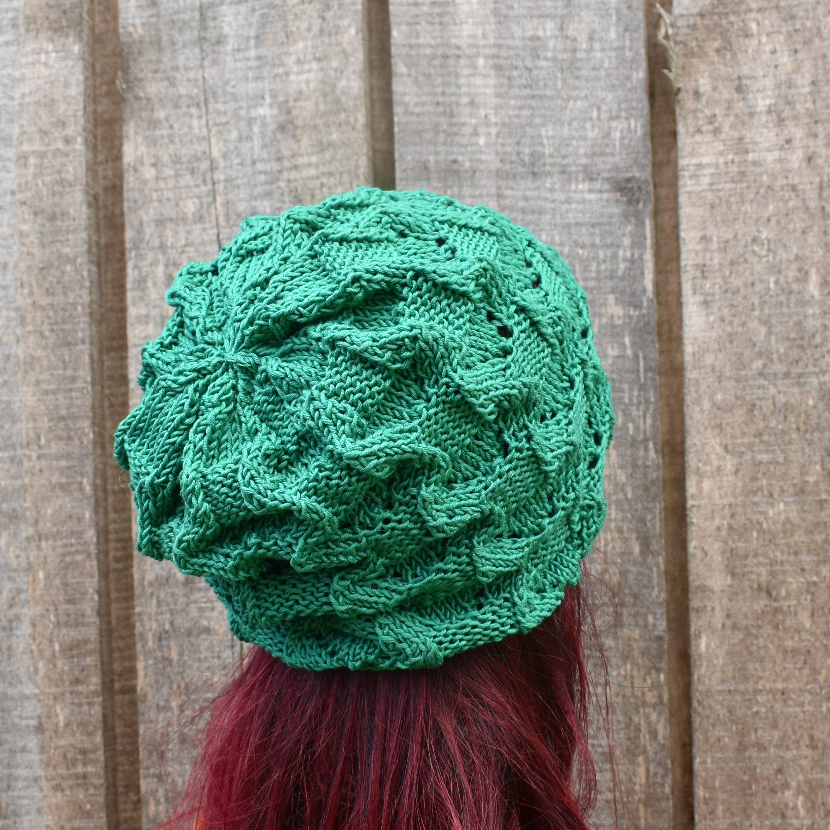 Green knitted hat on a person with red hair against a wooden background