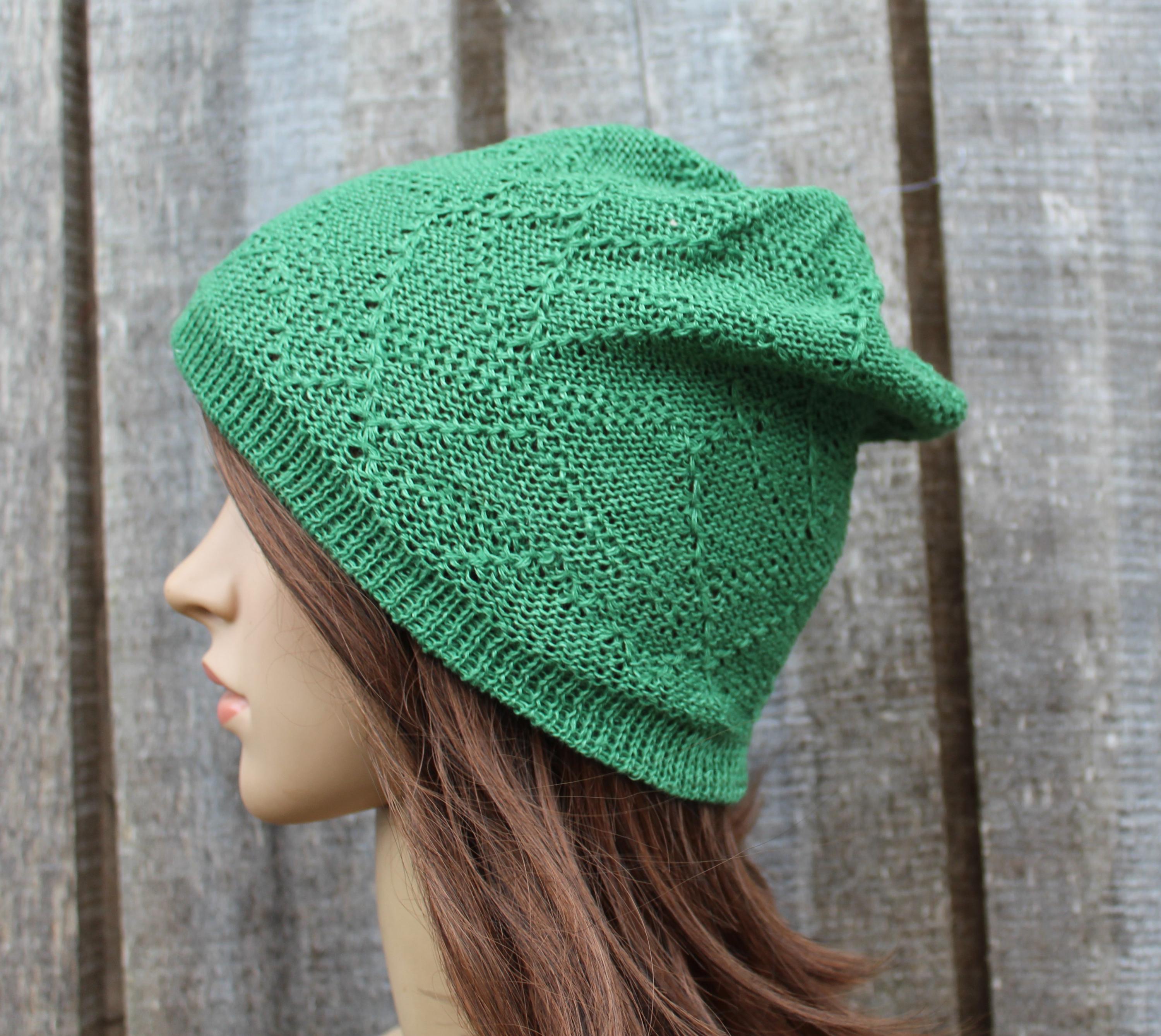 Green knitted hat on a mannequin head against a wooden background