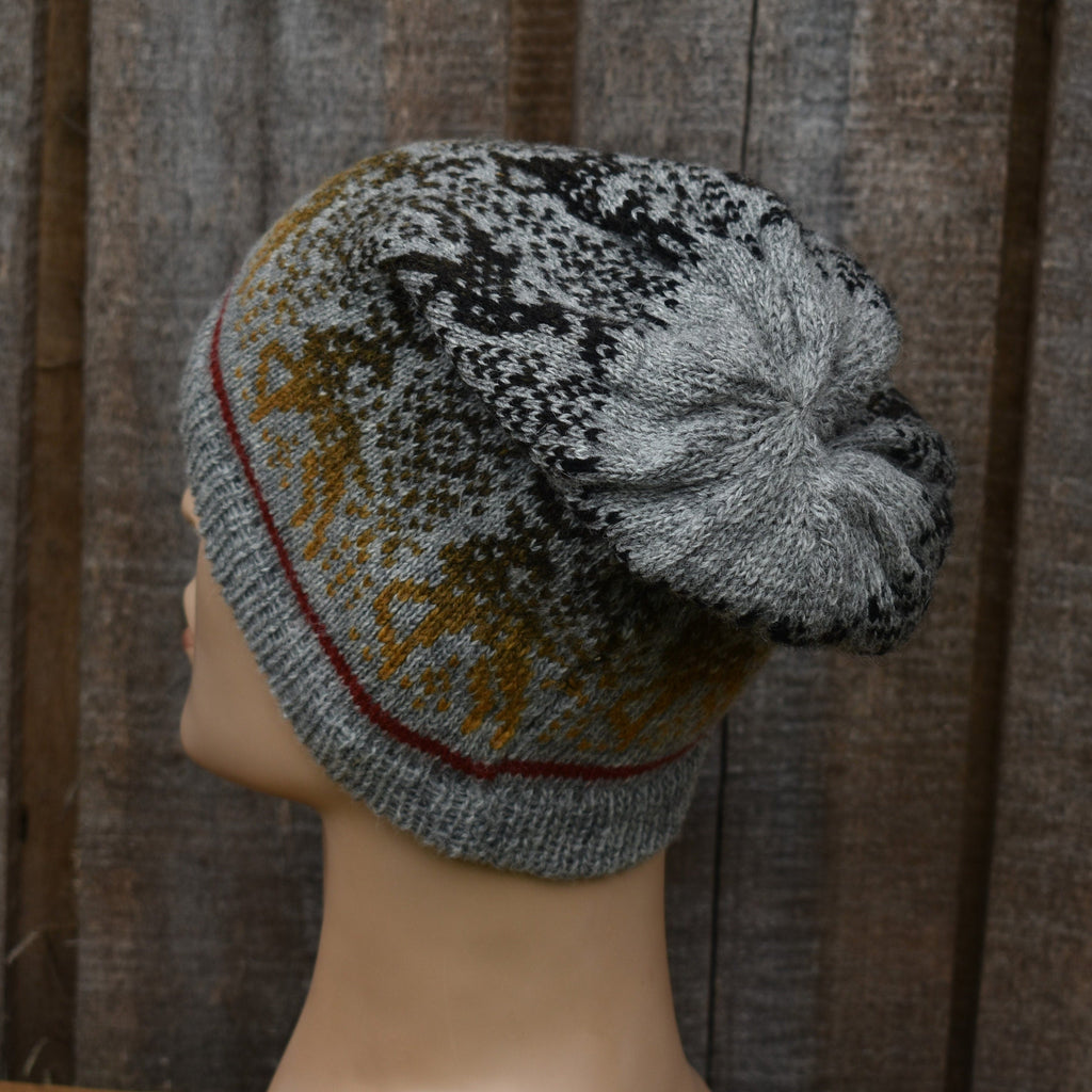 Knitted beanie with a pattern on a mannequin head against a wooden background