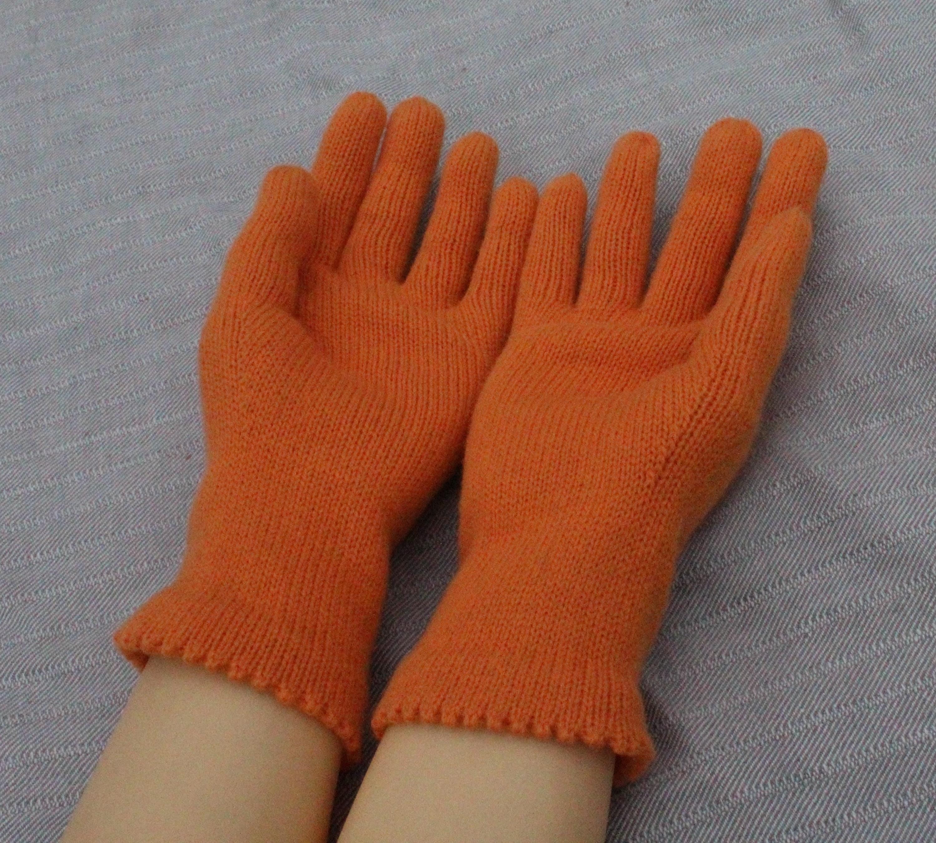 Pair of orange gloves on a gray background