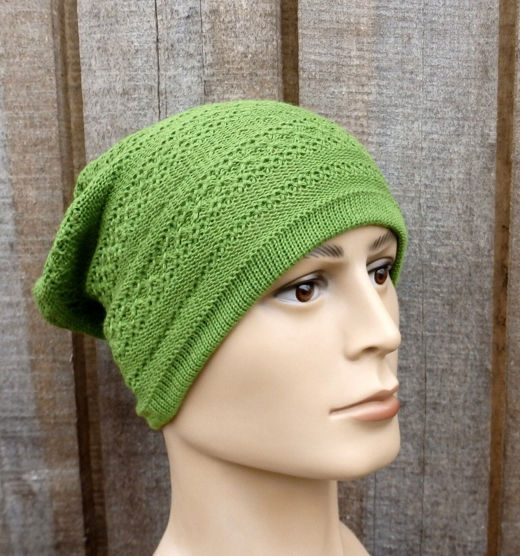 Green knitted beanie on a mannequin head against a wooden background