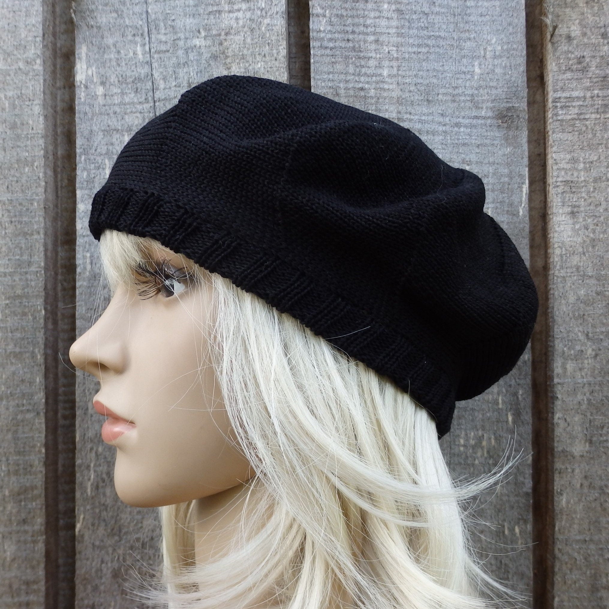 Black beanie on a mannequin head against a wooden background