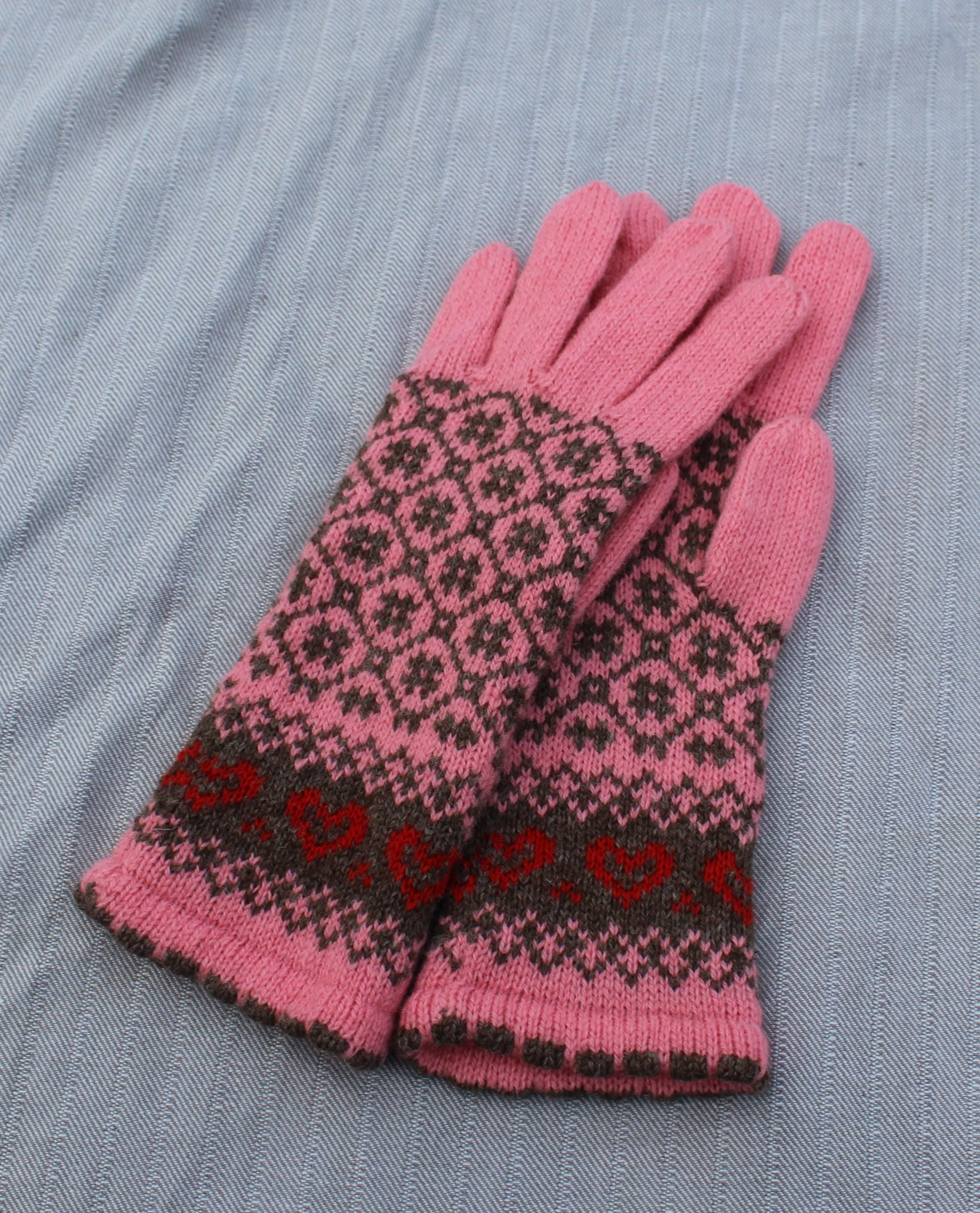 Pair of pink gloves with a black and red pattern on a gray surface