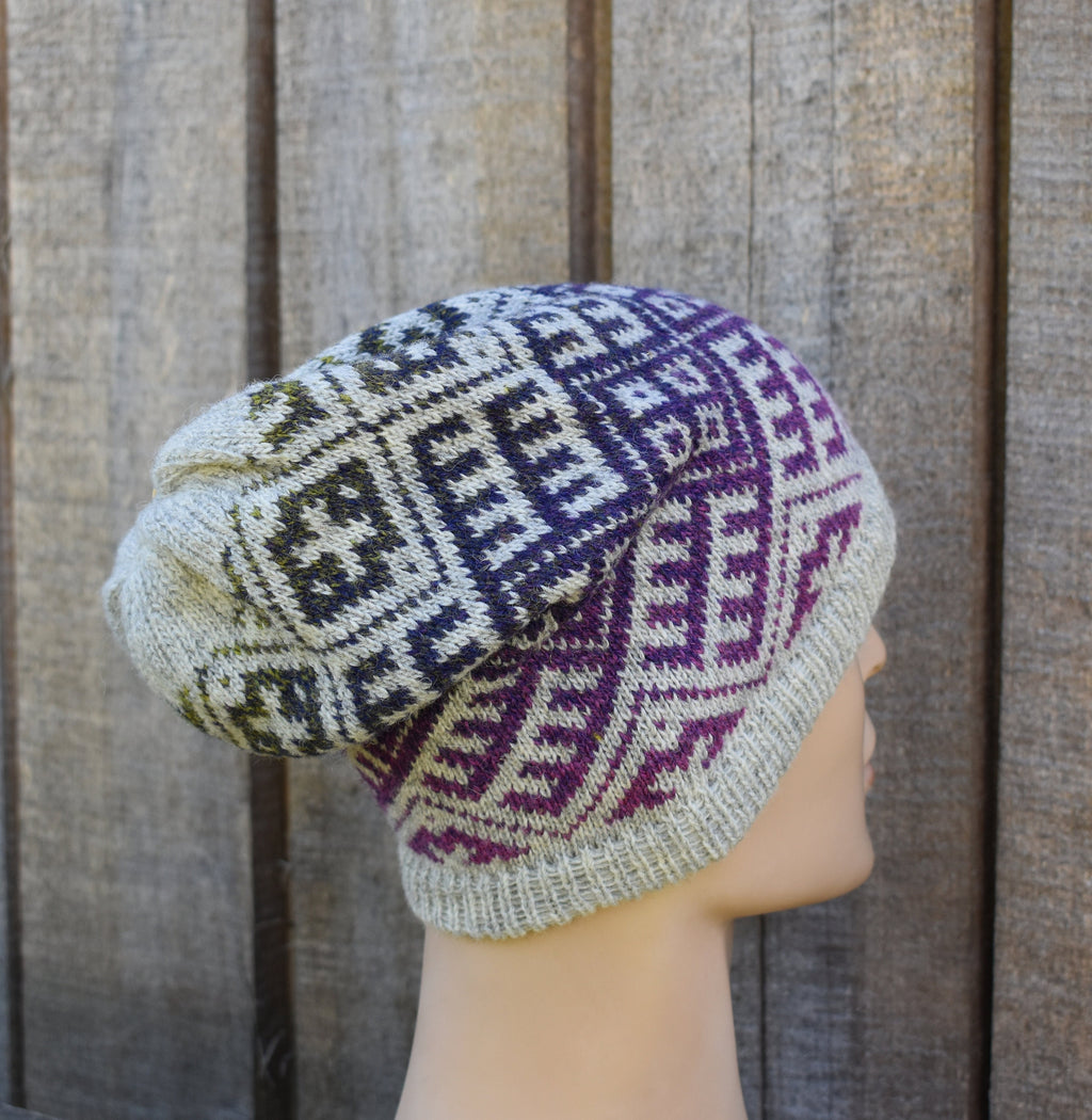 Knitted hat with geometric pattern on a mannequin head against a wooden background