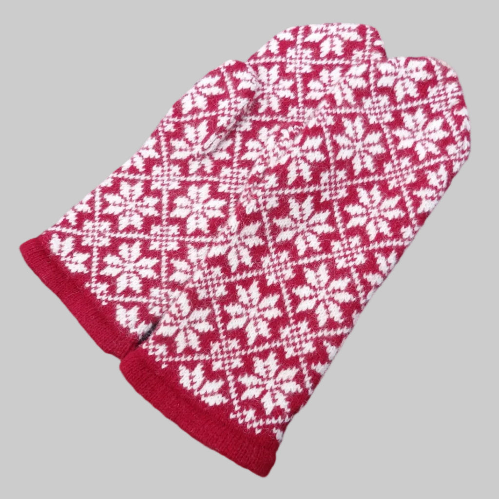 Red and white patterned mittens on a dark background