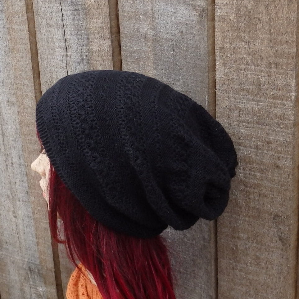 Person wearing a black knit beanie against a wooden background