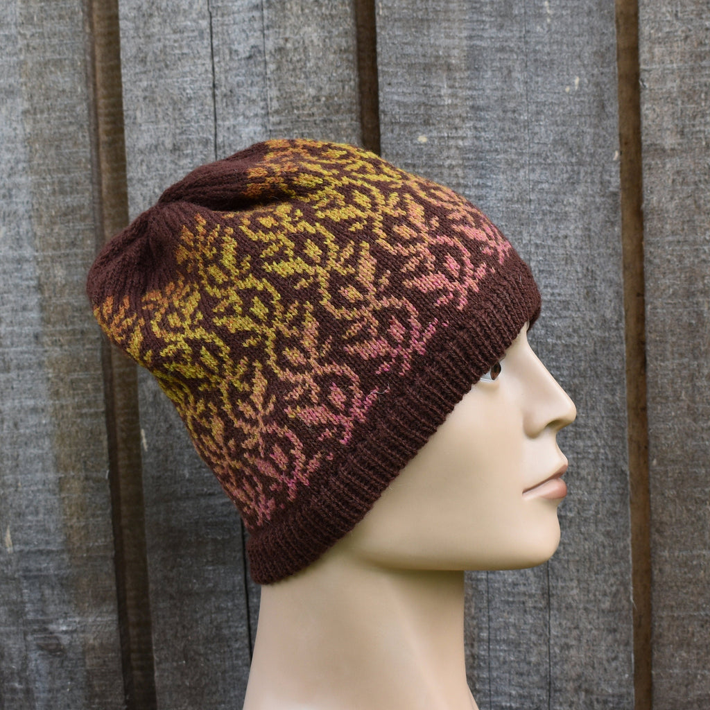 Knitted hat with a pattern on a mannequin head against a wooden background