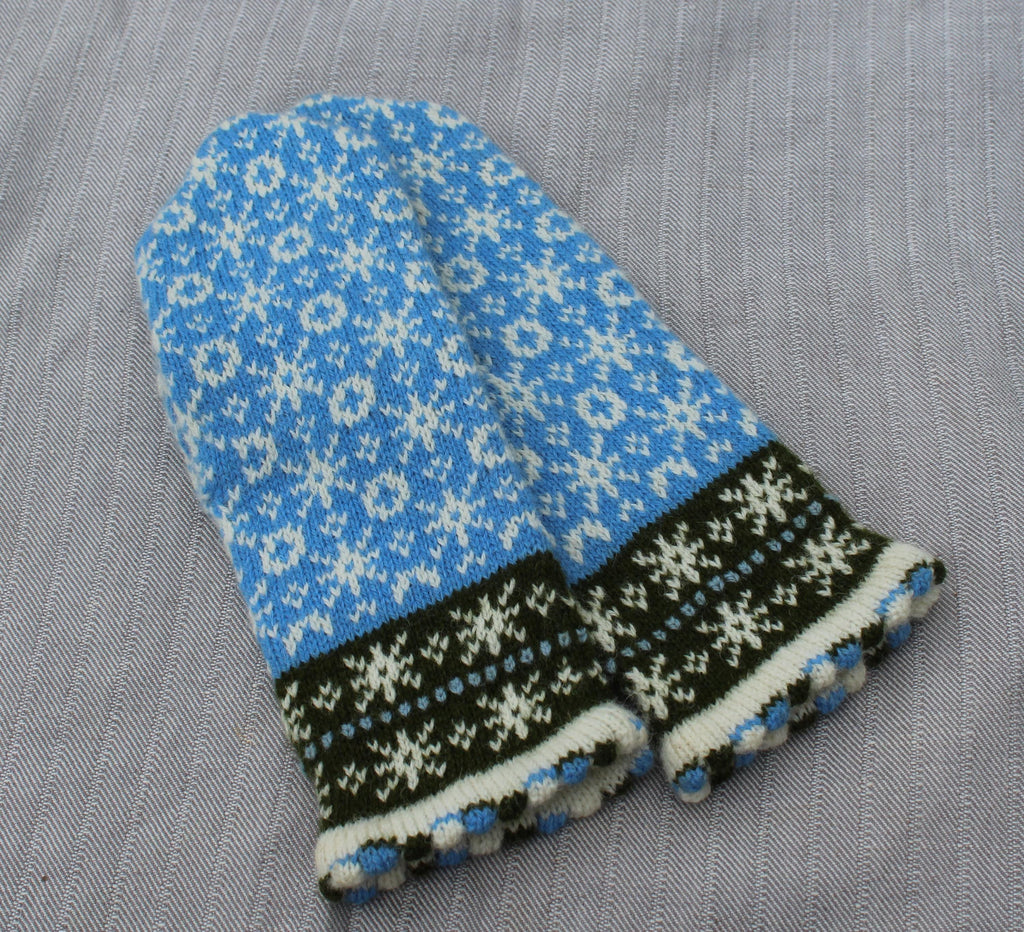Pair of blue and black patterned mittens on a gray background