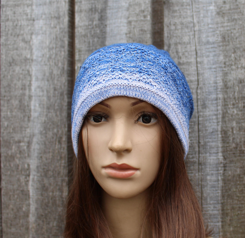 Blue knitted beanie on a mannequin head against a wooden background