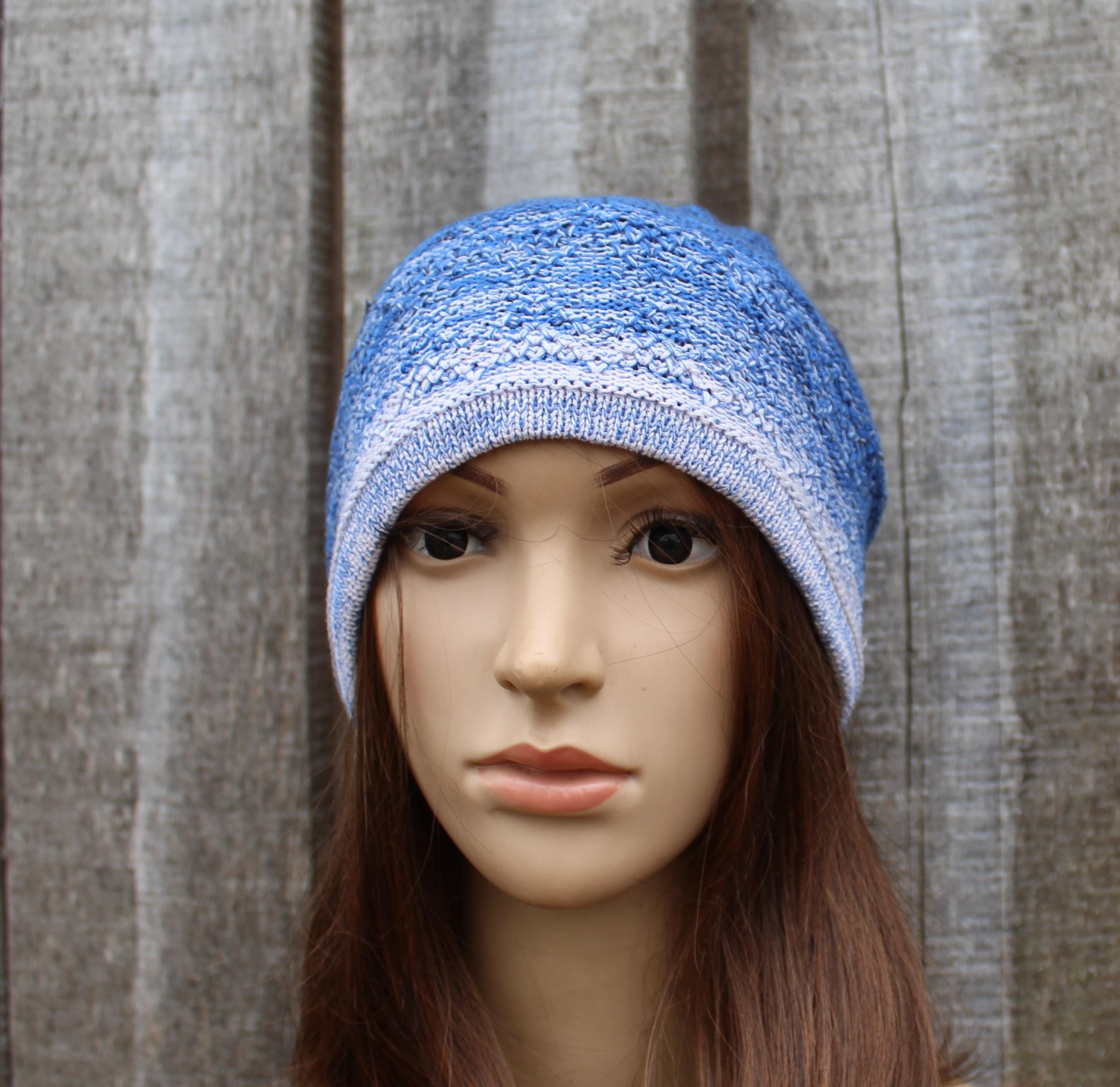 Blue knitted beanie on a mannequin head against a wooden background