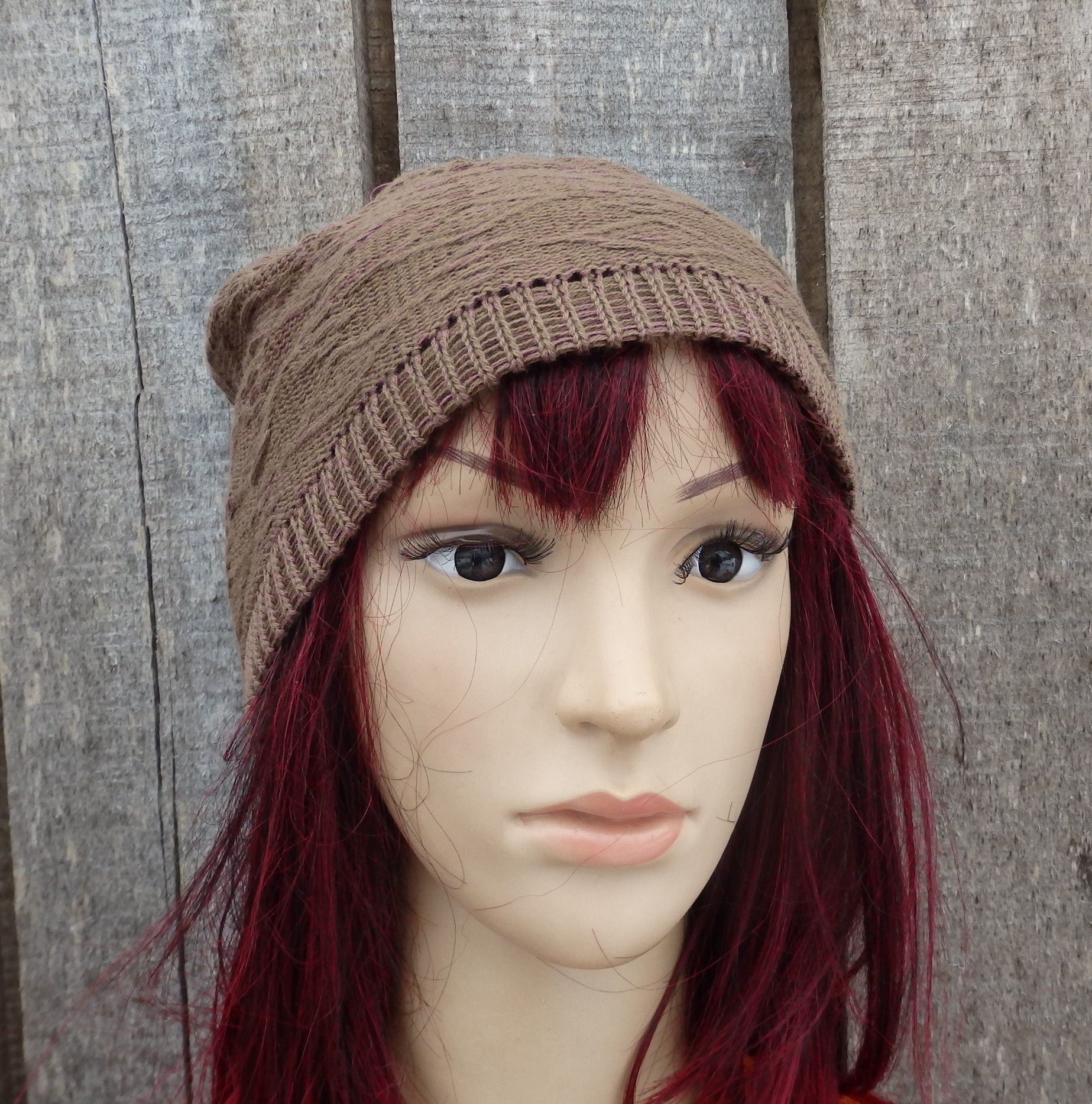 Mannequin head with brown knit beanie against a wooden background