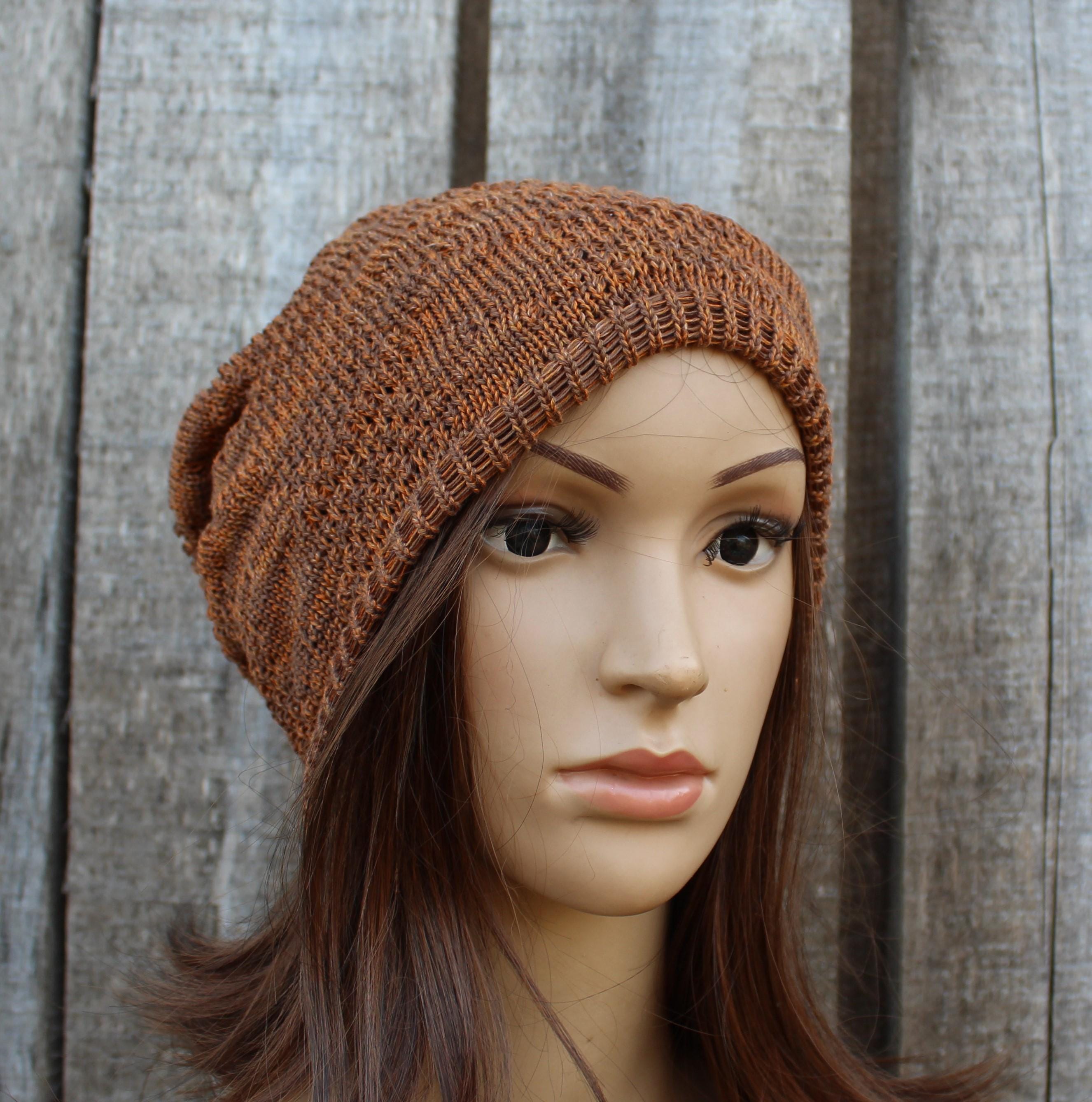 Brown knitted beanie on a mannequin head against a wooden background
