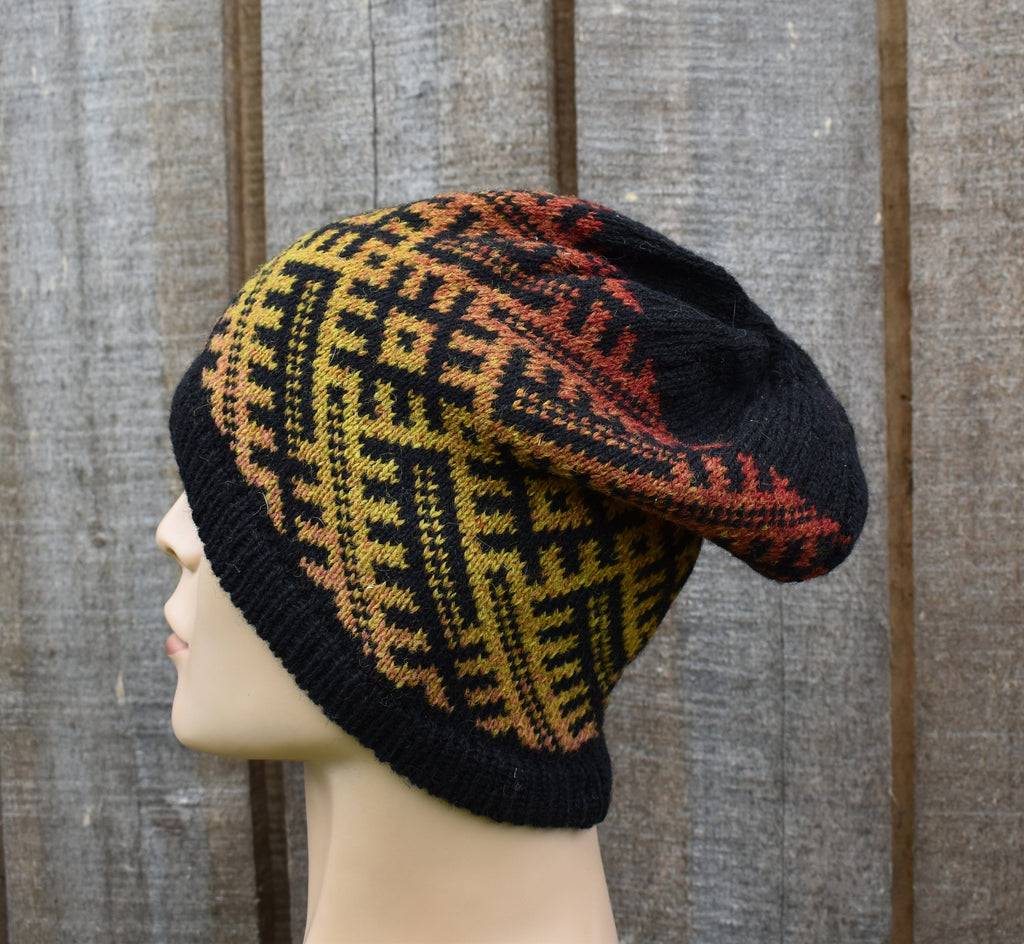 Knitted hat with geometric pattern on a mannequin head against a wooden background