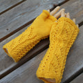 Yellow knitted arm warmers on a wooden surface
