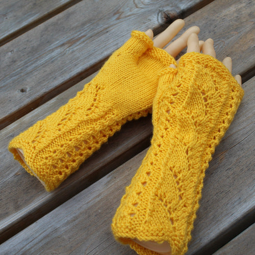 Yellow knitted arm warmers on a wooden surface