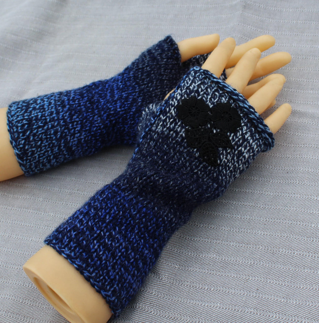 Blue knitted arm warmers on a mannequin arm against a gray background