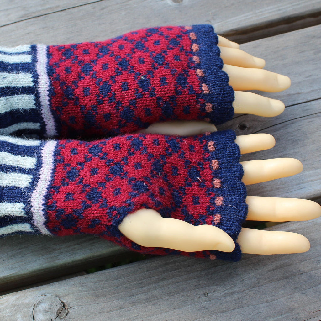 Pair of red and blue patterned fingerless gloves on a wooden surface