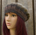 Mannequin head wearing a brown knitted hat against a wooden background