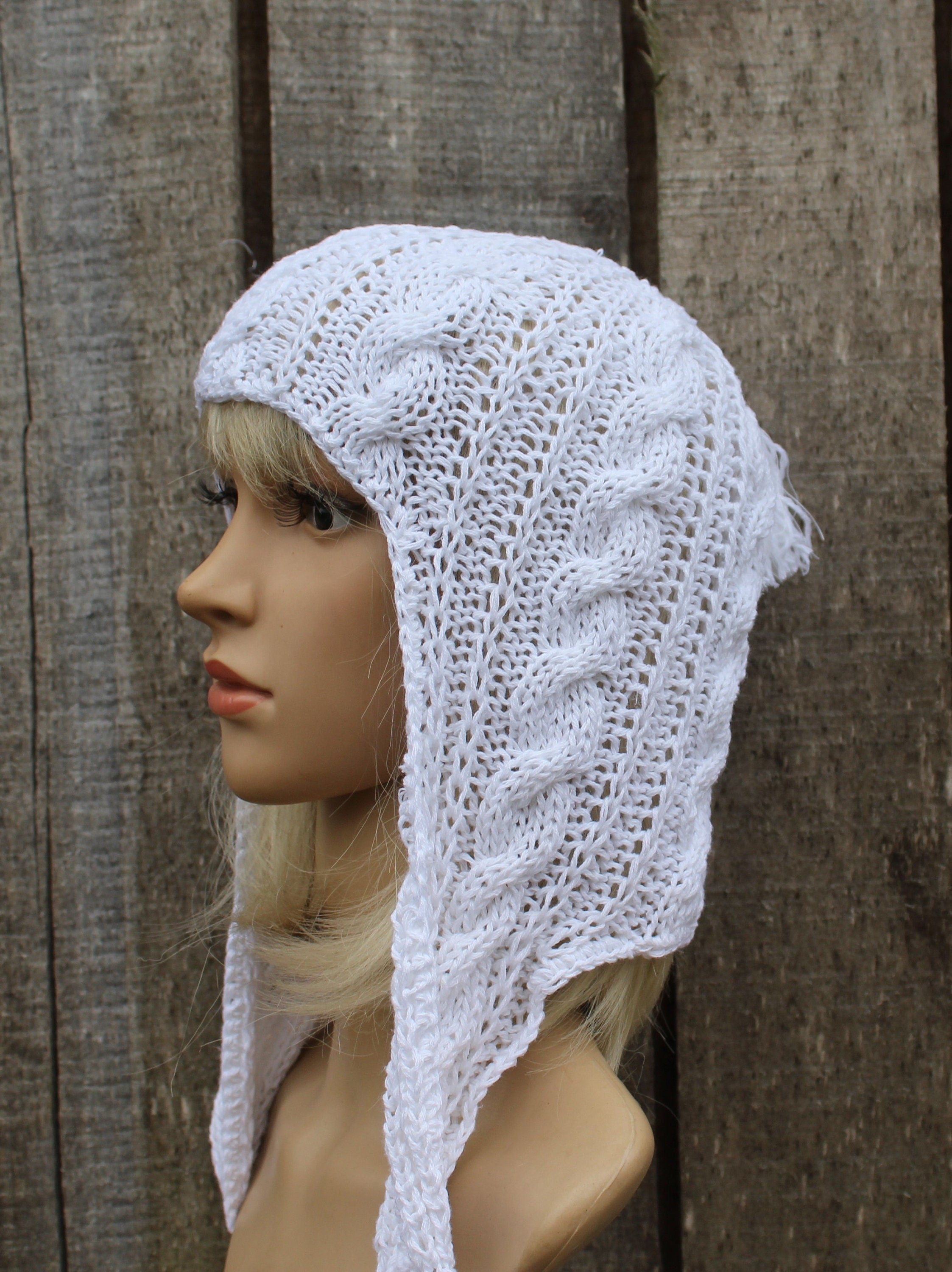 White knitted hood on a mannequin against a wooden background