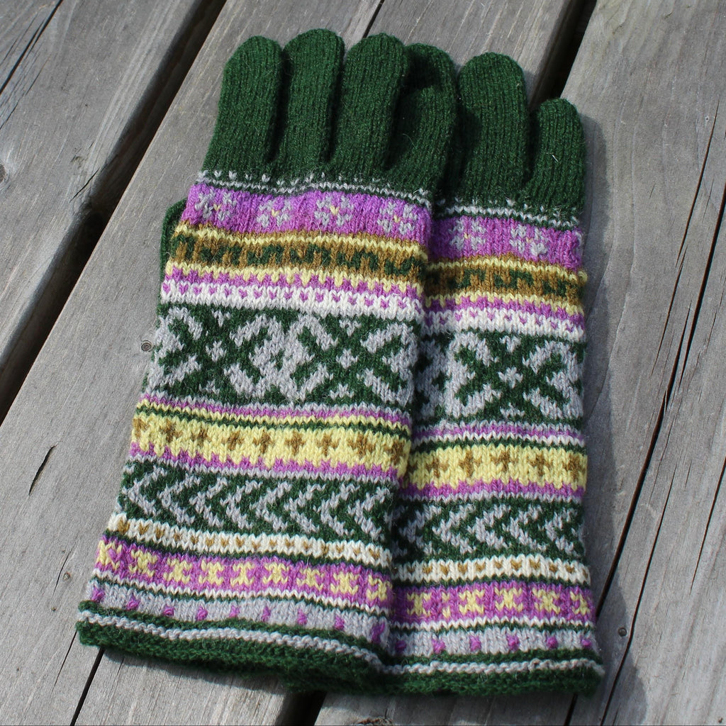 Pair of green gloves with a colorful pattern on a wooden surface