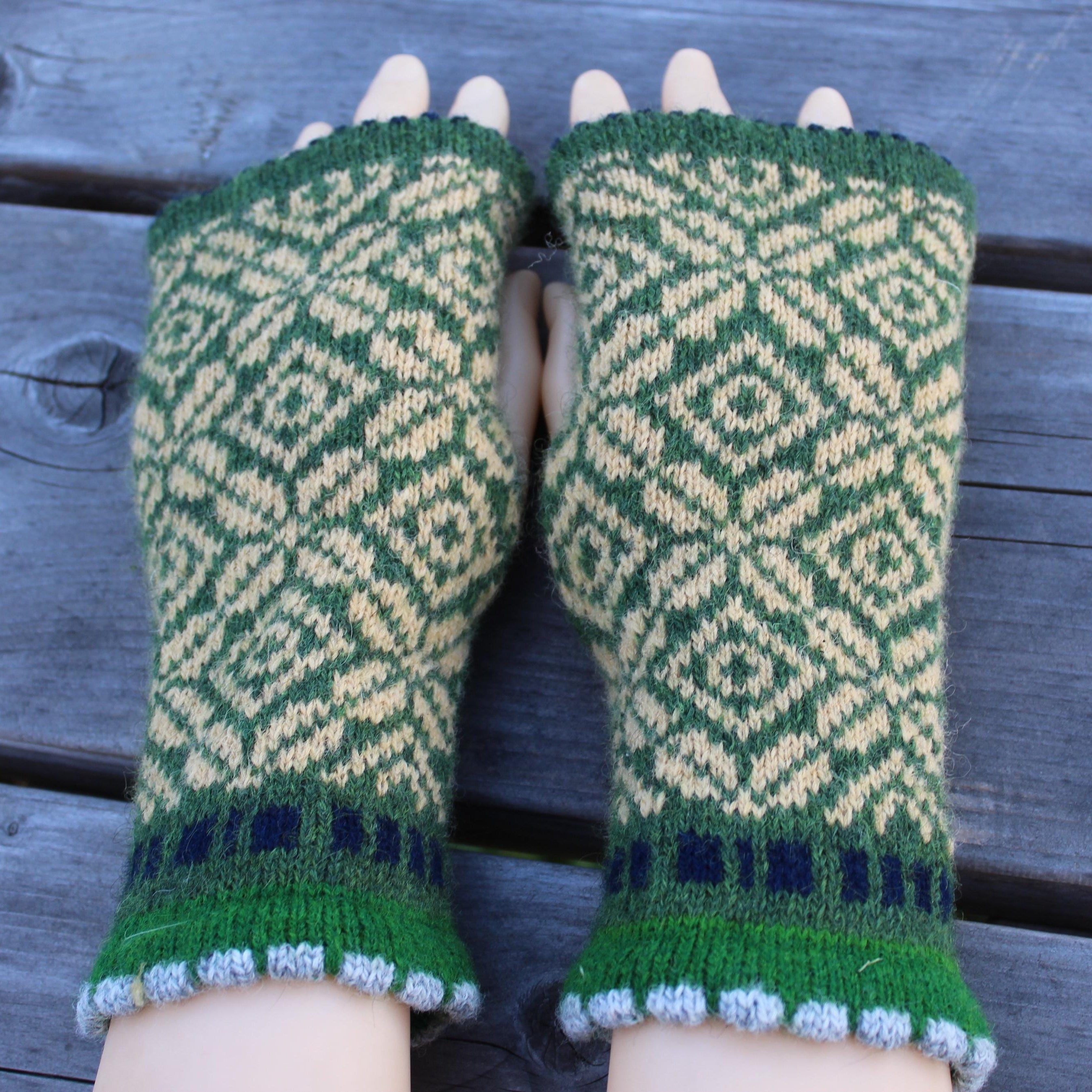 Green and  yellow patterned fingerless gloves on a wooden surface