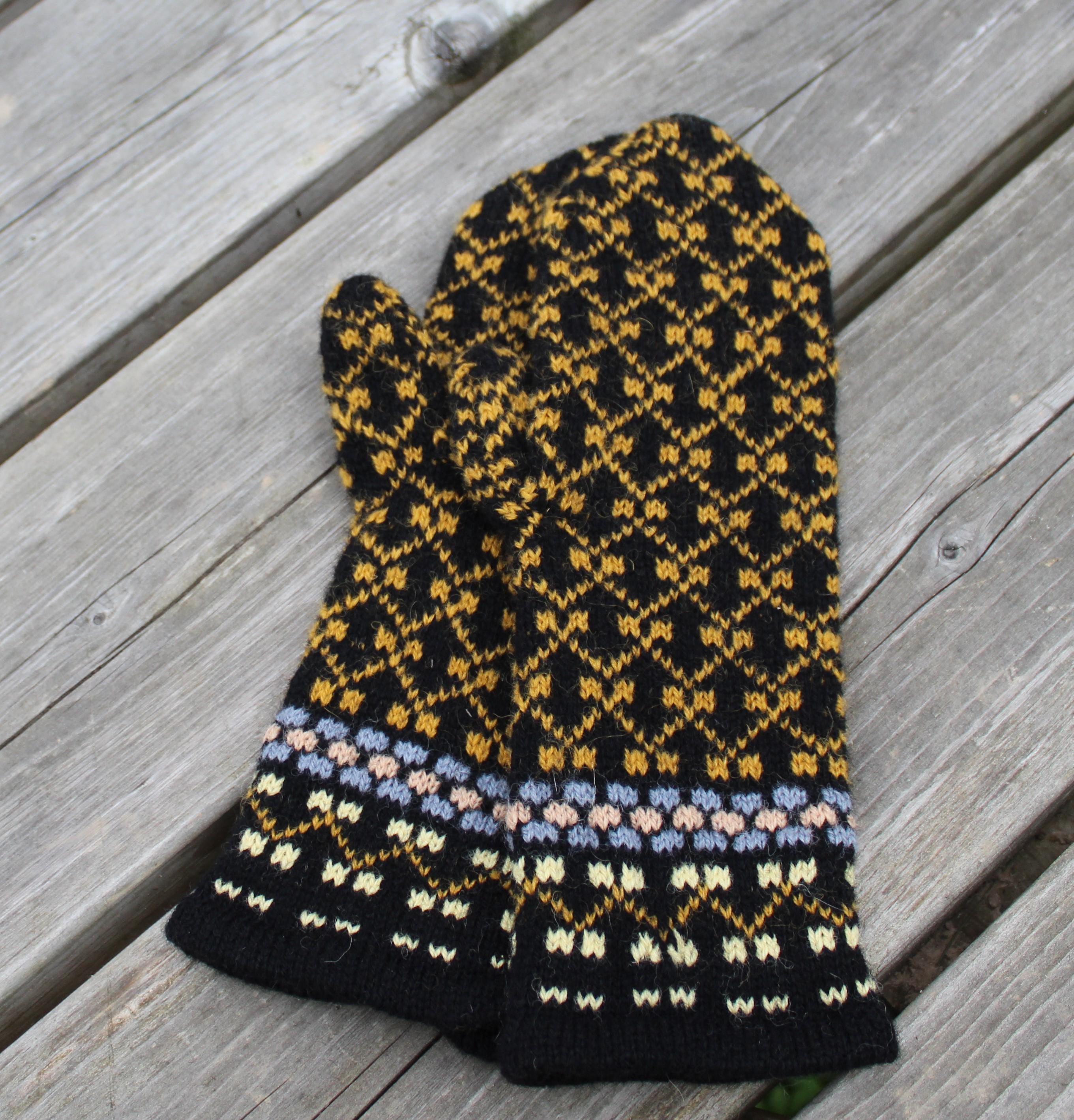 Knitted mittens with a geometric pattern on a wooden surface