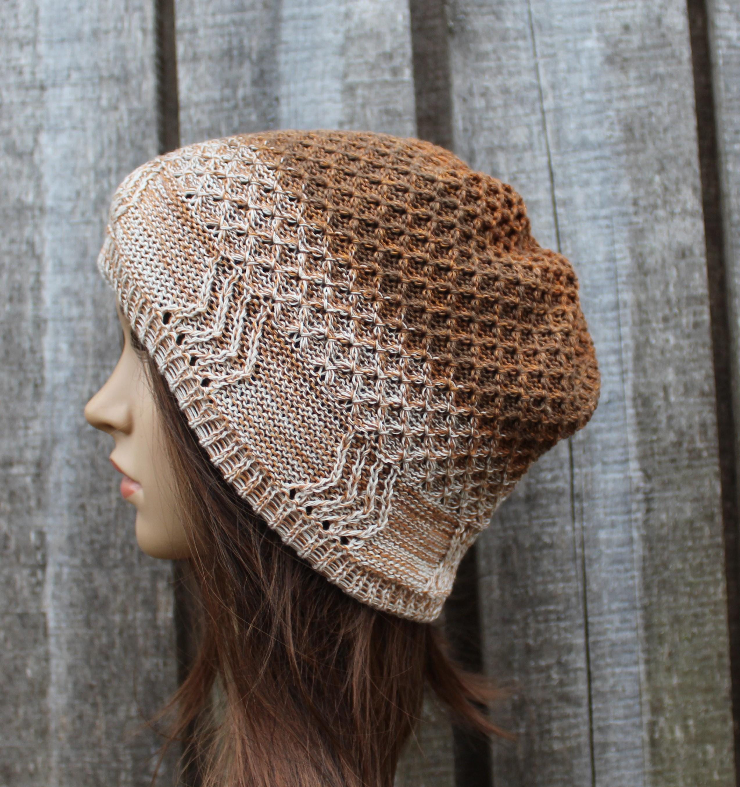 Knitted brown and beige hat on a mannequin head against a wooden background